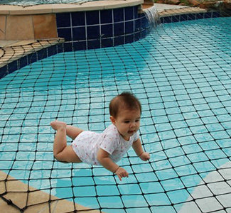 Baby crawling on a pool net with blue tiled edges