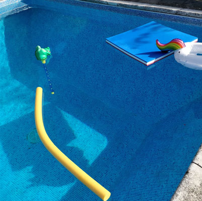 A swimming pool with flotation toys floating in the water