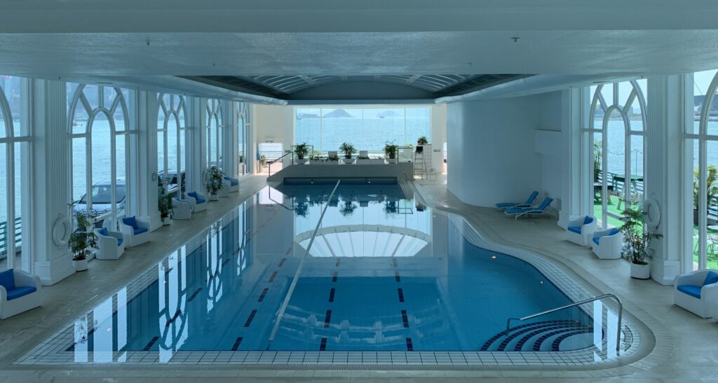 An indoor swimming pool overlooking a body of water.